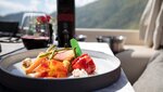 An elegant dish with wine and a beautiful view.